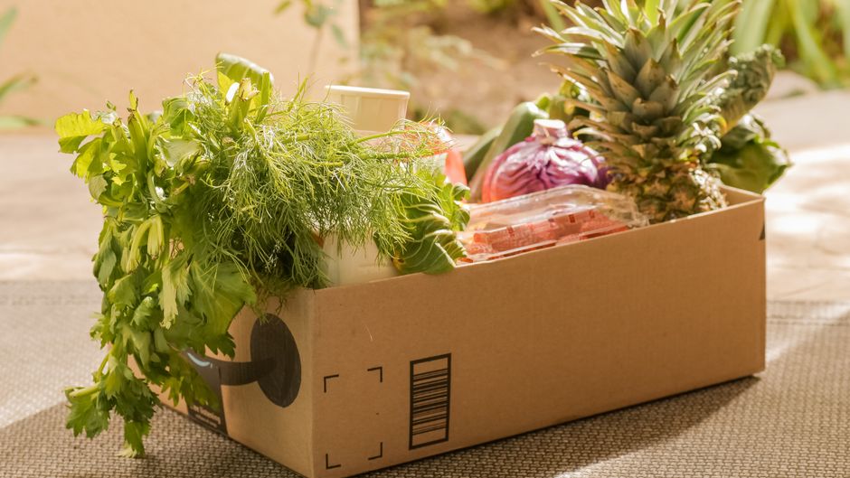 Кур'єр пакує еко-коробку з продуктами